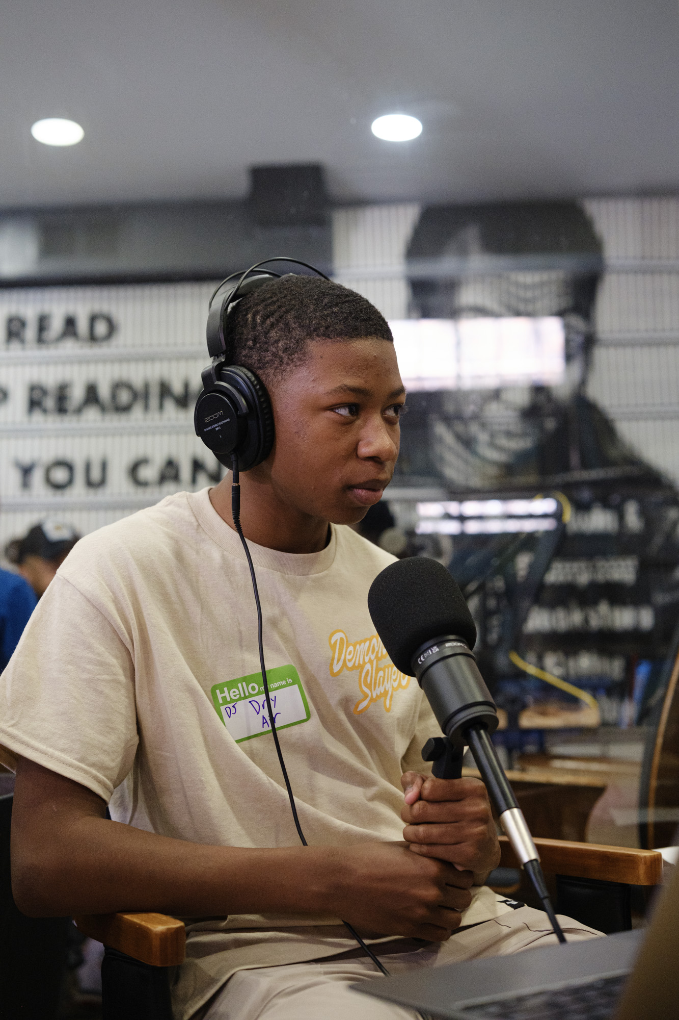 A young person with headphones at the mic during a Be Loud session
